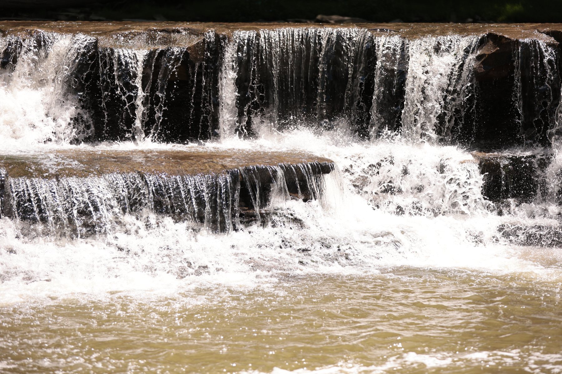 Waterfall flowing over a broad stone shelf.